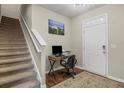 Entryway view featuring hardwood floors, stairs, and a workstation with natural light at 8553 Braylen Manor Dr, Douglasville, GA 30134