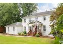 Beautiful two-story white brick home with inviting front porch and well-manicured lawn at 5070 Hensley Dr, Atlanta, GA 30338