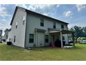 Home back exterior featuring a covered patio with siding and well kept lawn at 7487 Rudder Cir, Fairburn, GA 30213