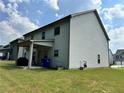 A home's backyard, featuring siding, a covered patio, and a well-maintained lawn at 7487 Rudder Cir, Fairburn, GA 30213