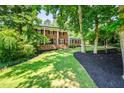 Charming two-story brick home with black mulch, lush green lawn, and shade trees at 285 Jade Cove Dr, Roswell, GA 30075