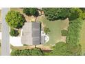 Aerial shot of the home's backyard, featuring a patio area and ample green space, surrounded by mature trees and landscaping at 4345 Idlewood Dr, Cumming, GA 30040