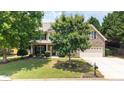 Attractive home with a brick and siding exterior, complemented by a lush green lawn and mature trees at 4345 Idlewood Dr, Cumming, GA 30040