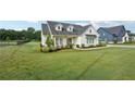 Charming modern farmhouse on a lush green lawn with mature landscaping and dark metal perimeter fence at 4720 Down Setting Rd, Cumming, GA 30028