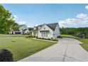 Charming modern farmhouse with a well-manicured lawn and a long driveway leading to the attached garage at 4720 Down Setting Rd, Cumming, GA 30028