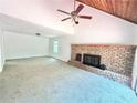 Bright living room featuring carpeted floors, a brick fireplace, and a ceiling fan at 5968 Hilltop Dr, Douglasville, GA 30135