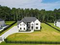 Beautiful home featuring a well-maintained lawn, a long driveway, and black fencing at 3207 Bold Springs Rd, Dacula, GA 30019