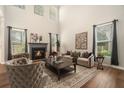 Elegant living room with a cozy fireplace, high ceilings, and large windows, allowing natural light at 429 Mountain View Ln, Woodstock, GA 30188