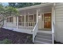 Inviting front entrance with a stained wood door, white painted brick, columns and gray painted steps at 4669 Dunover Cir, Atlanta, GA 30360