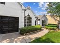 Beautiful home with manicured green landscaping and black garage door with a paver walkway and a large window at 3208 Spruce Way, Atlanta, GA 30349