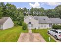Charming home exterior with a long driveway and lush green lawn surrounded by a beautiful tree line at 6178 Field Stone Dr, Douglasville, GA 30134