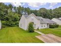 Exterior view of a charming home with a well-manicured lawn surrounded by lush greenery and mature trees at 6178 Field Stone Dr, Douglasville, GA 30134