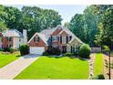 Inviting brick and stone home with lush lawn and mature trees at 830 Club Chase Ct, Roswell, GA 30076