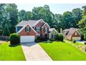 Beautiful brick home featuring manicured lawn and a two car garage at 830 Club Chase Ct, Roswell, GA 30076