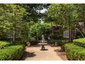 Brick building featuring mature trees, manicured hedges, and fountain at 737 Barnett Ne St # B6, Atlanta, GA 30306
