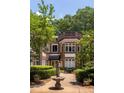 Brick exterior of 'The Barnett' features a charming fountain and manicured landscaping at 737 Barnett Ne St # B6, Atlanta, GA 30306