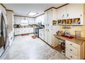 The full kitchen features a stainless steel refrigerator, white cabinets, and a skylight at 261 Clayton Trl, Canton, GA 30114