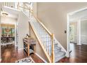 Inviting foyer featuring hardwood floors, a staircase with white banisters, and views into the dining and living areas at 3117 Blowing Wind Nw Ct, Acworth, GA 30101
