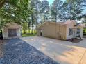 View of the detached storage building and the back of the house with a concrete driveway at 413 Old Brock Rd, Rockmart, GA 30153