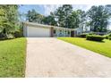 Long driveway leading to a one-story home with an attached garage and well-manicured lawn at 4094 Colgate Way, Decatur, GA 30034