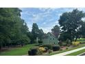 Landscaped home featuring lush greenery and a well-maintained lawn at 4185 Lenox Park Dr, Buford, GA 30519