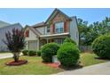 View of the front lawn with mature shrubs and red mulch at 574 Friars Head Dr, Suwanee, GA 30024
