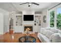 Bright living room featuring a fireplace, built-in shelving, coffered ceilings, and hardwood floors at 454 Pine Bluff Dr, Dallas, GA 30157