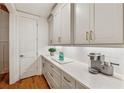 Butler's pantry features sleek white cabinets, quartz counters, subway tile backsplash, and modern fixtures at 214 Trecastle Sq, Canton, GA 30114