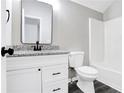 Modern bathroom with granite countertop, black fixtures, white cabinets, and a shower-tub combo at 381 New Jersey Ave Nw, Atlanta, GA 30314