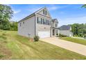 Angle view of a two-story home with brick and siding, a spacious lawn, and driveway at 4323 Cannon Walk, Ellenwood, GA 30294