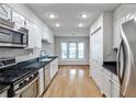 Bright kitchen boasts stainless steel appliances, hardwood floors, and a view to the breakfast nook at 52 Sutton Pl, Avondale Estates, GA 30002