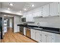 Kitchen features stainless steel appliances, white cabinets, and hardwood floors at 52 Sutton Pl, Avondale Estates, GA 30002