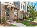 Inviting townhome entrance with brick facade, covered entryway, and manicured landscaping at 5440 Howington Ct # 190, Buford, GA 30518
