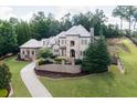 Beautiful stone home with well-maintained lawn and landscaped grounds on a sunny day at 9695 Almaviva Dr, Alpharetta, GA 30022