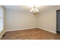 Spacious dining room with wood-look flooring, chandelier, and abundant natural light at 110 Paddock Trl, Peachtree City, GA 30269
