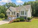 Charming split-level home with stone accents, two-car garage and inviting, red-painted staircase at 2355 Woodland Hills Dr, Cumming, GA 30040