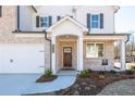 Charming home featuring a brick facade, inviting entryway with decorative columns, and a two-car garage at 1712 Fulmont Cir, Mableton, GA 30126
