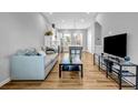 Bright open-concept living room with hardwood floors, comfortable seating, and a modern, eat-in kitchen area at 2022 Bixby Byway Se Rd, Atlanta, GA 30317