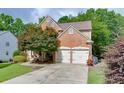 View of the two-car garage and brick exterior of this lovely traditional home at 457 Skiles Ct, Suwanee, GA 30024