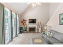 Cozy living room with a fireplace, large windows, and vaulted ceilings at 120 Ashewoode Downs Ln, Alpharetta, GA 30005