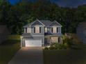 Beautiful home at dusk with manicured lawn and ambient lighting, creating a warm and welcoming atmosphere at 525 Clinton Dr, Temple, GA 30179
