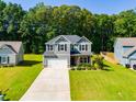 Inviting two-story home with a wide driveway and lush green lawn, perfect for Gathering living at 525 Clinton Dr, Temple, GA 30179