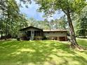 Charming home with a screened porch, surrounded by lush green lawn and mature trees at 125 Cannongate Cir, Sharpsburg, GA 30277