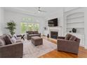 Bright living room with large windows, fireplace, hardwood floors and neutral decor, creating a cozy atmosphere at 4089 Thorndale Ln # 13, Smyrna, GA 30080