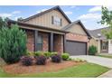 Well-manicured front lawn with mature landscaping complements the home's brick and siding exterior at 115 Court Xing, Locust Grove, GA 30248