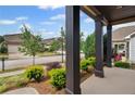 Inviting front porch with dark wood columns and views of the street and landscaped front yard at 115 Court Xing, Locust Grove, GA 30248