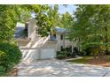 Lovely stucco home with a two-car garage, inviting entrance, and mature trees at 1950 Wenlok Ne Trl, Marietta, GA 30066