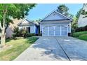 Charming single-story home with a well-manicured lawn and a two-car garage in a suburban neighborhood at 2220 Lily Valley Dr, Lawrenceville, GA 30045