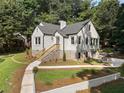 Rear view of home featuring painted brick, manicured yard and lush tree coverage at 2249 Beecher Sw Rd, Atlanta, GA 30311