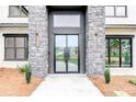 Close up of modern front door with transom window and stone surround at 2900 Waterford Dr Sw, Conyers, GA 30094